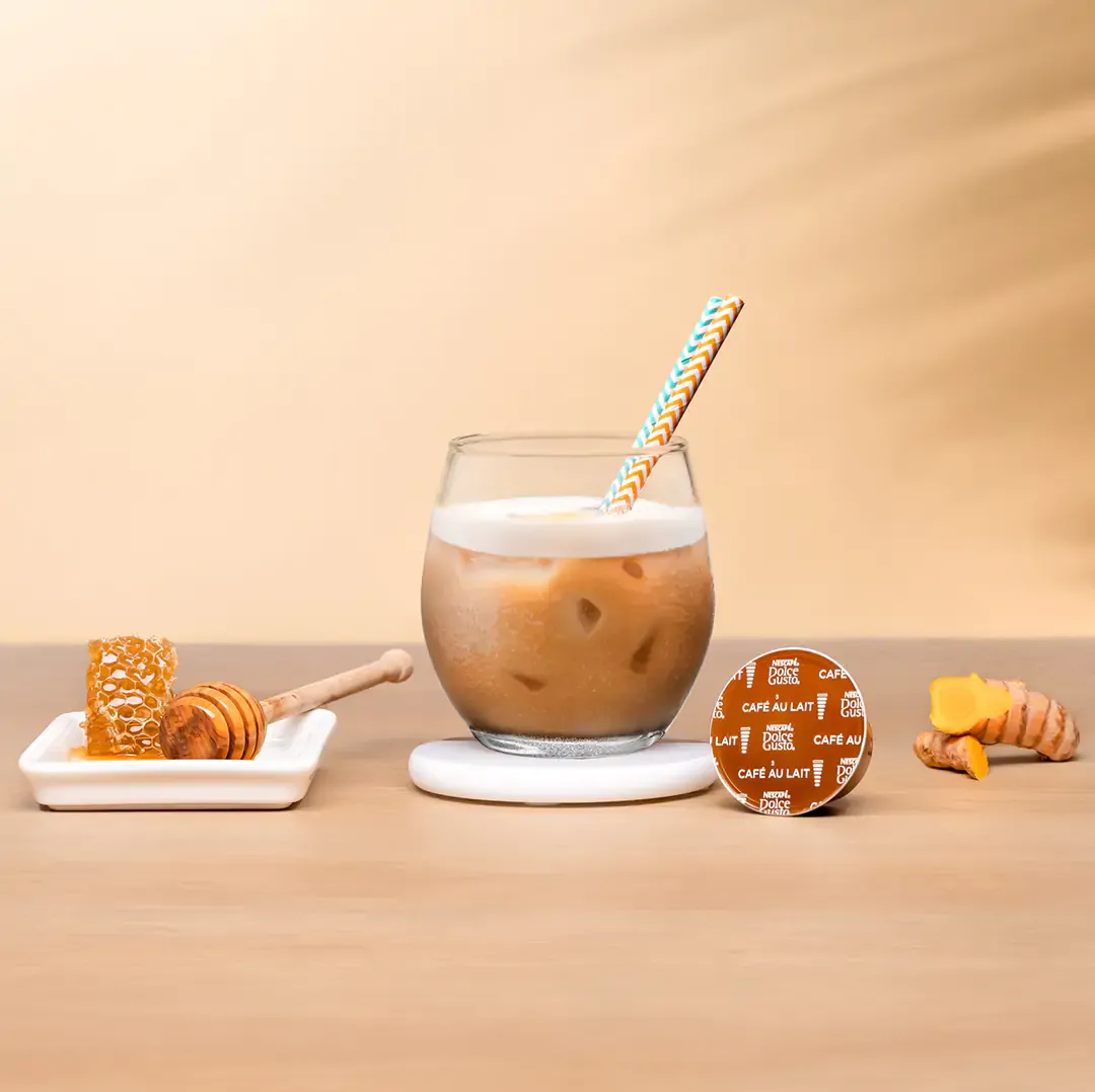 iced latte next to a coffee capsule